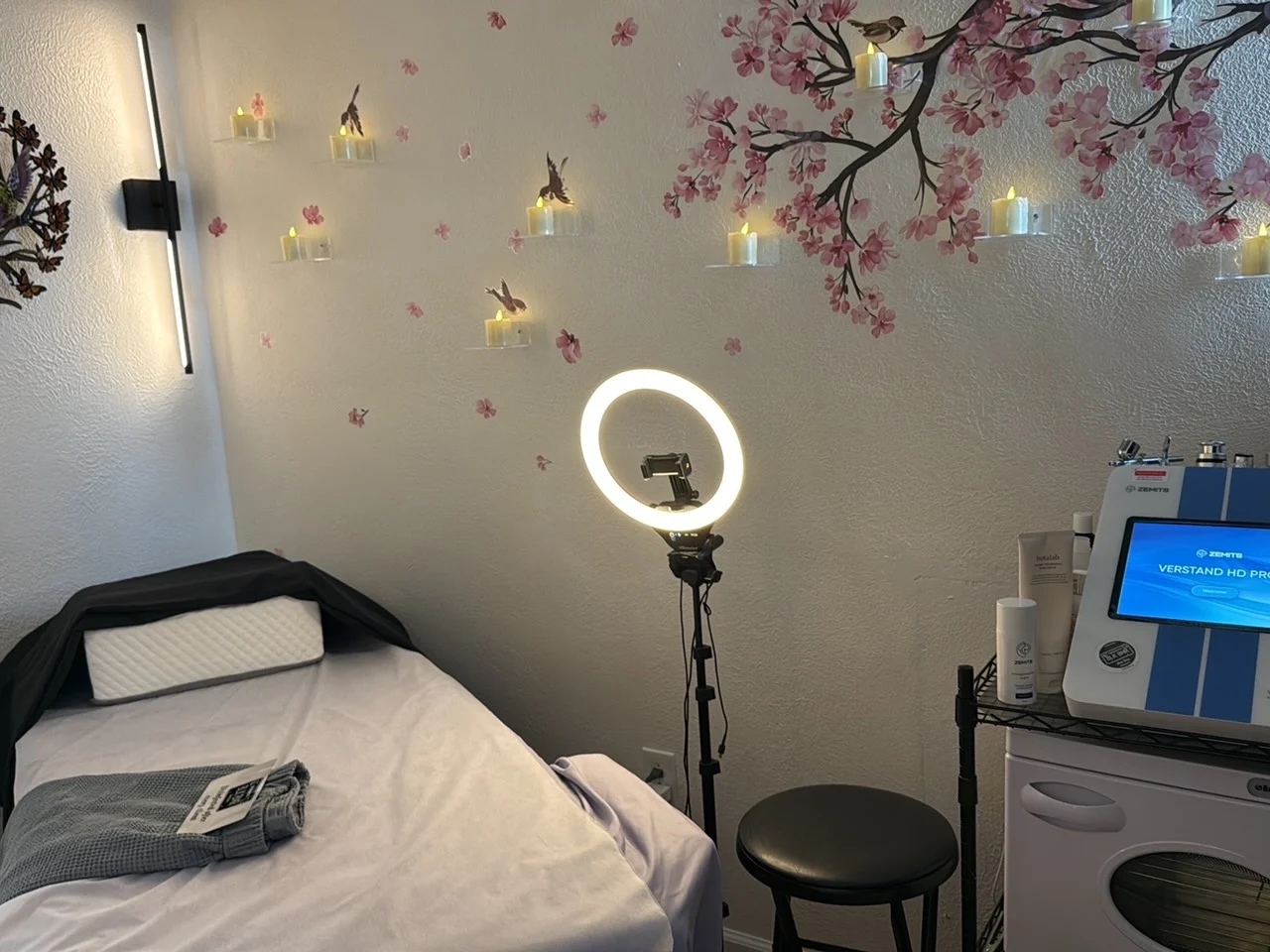 Treatment bed with ring light and cherry blossom wall