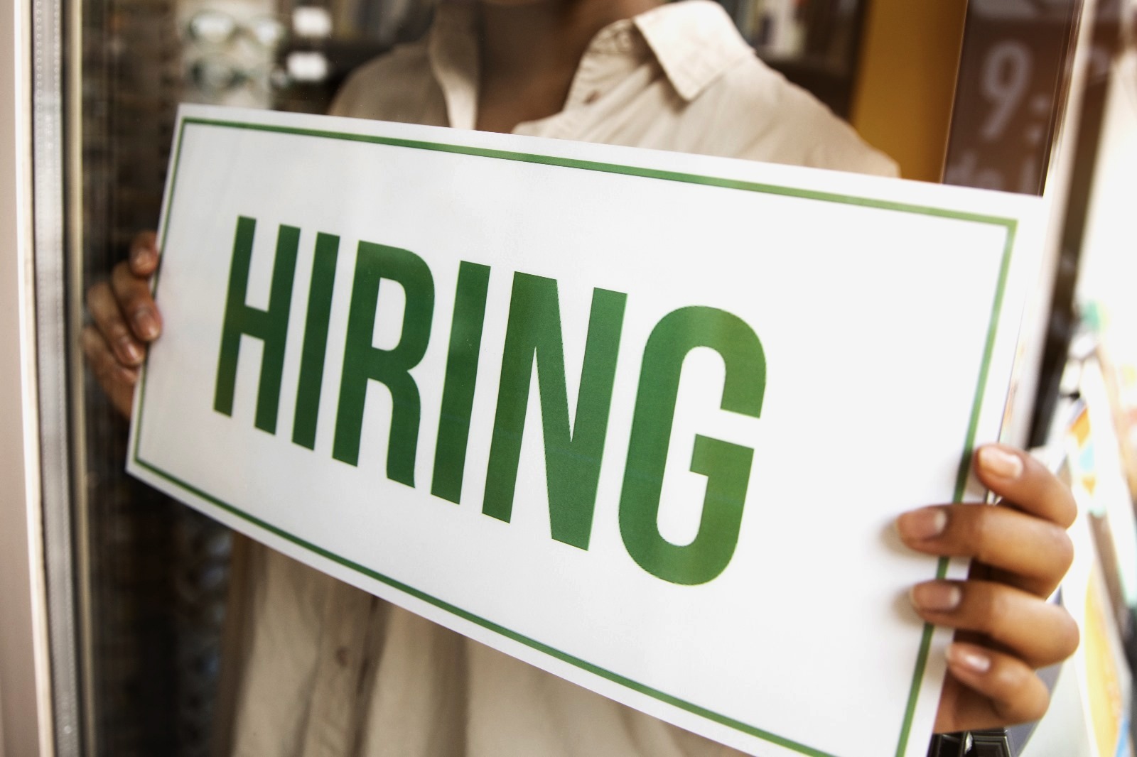 A person holding a hiring sign