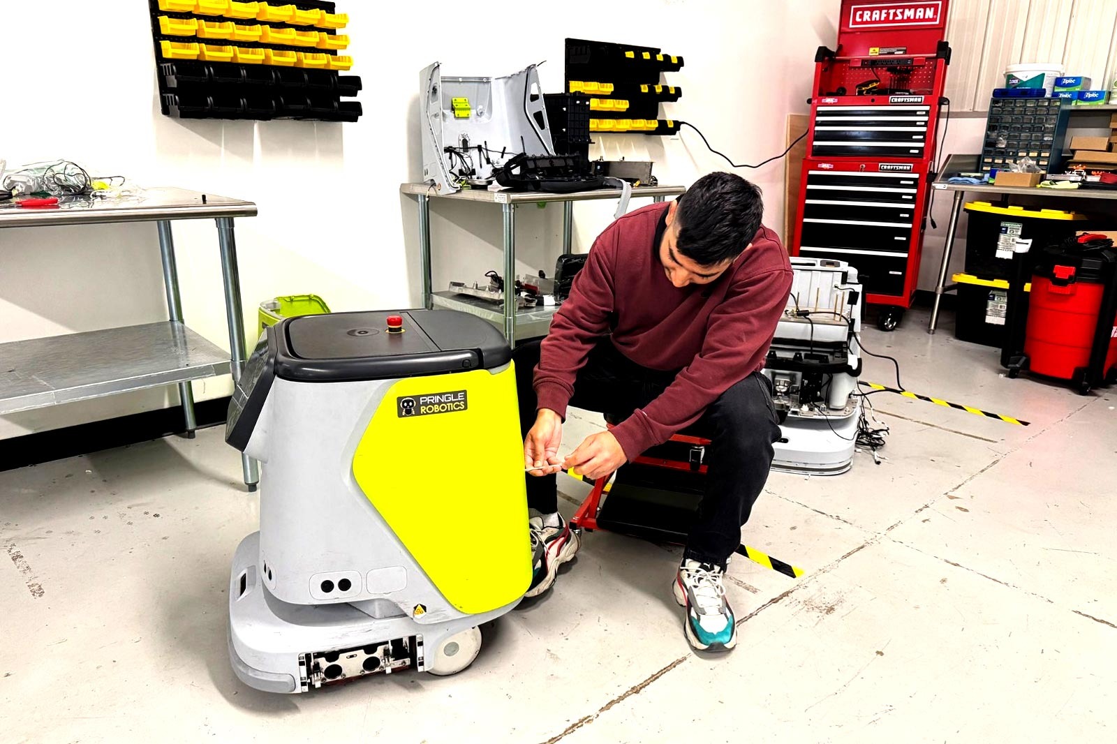 A technician works on a floor cleaning robot