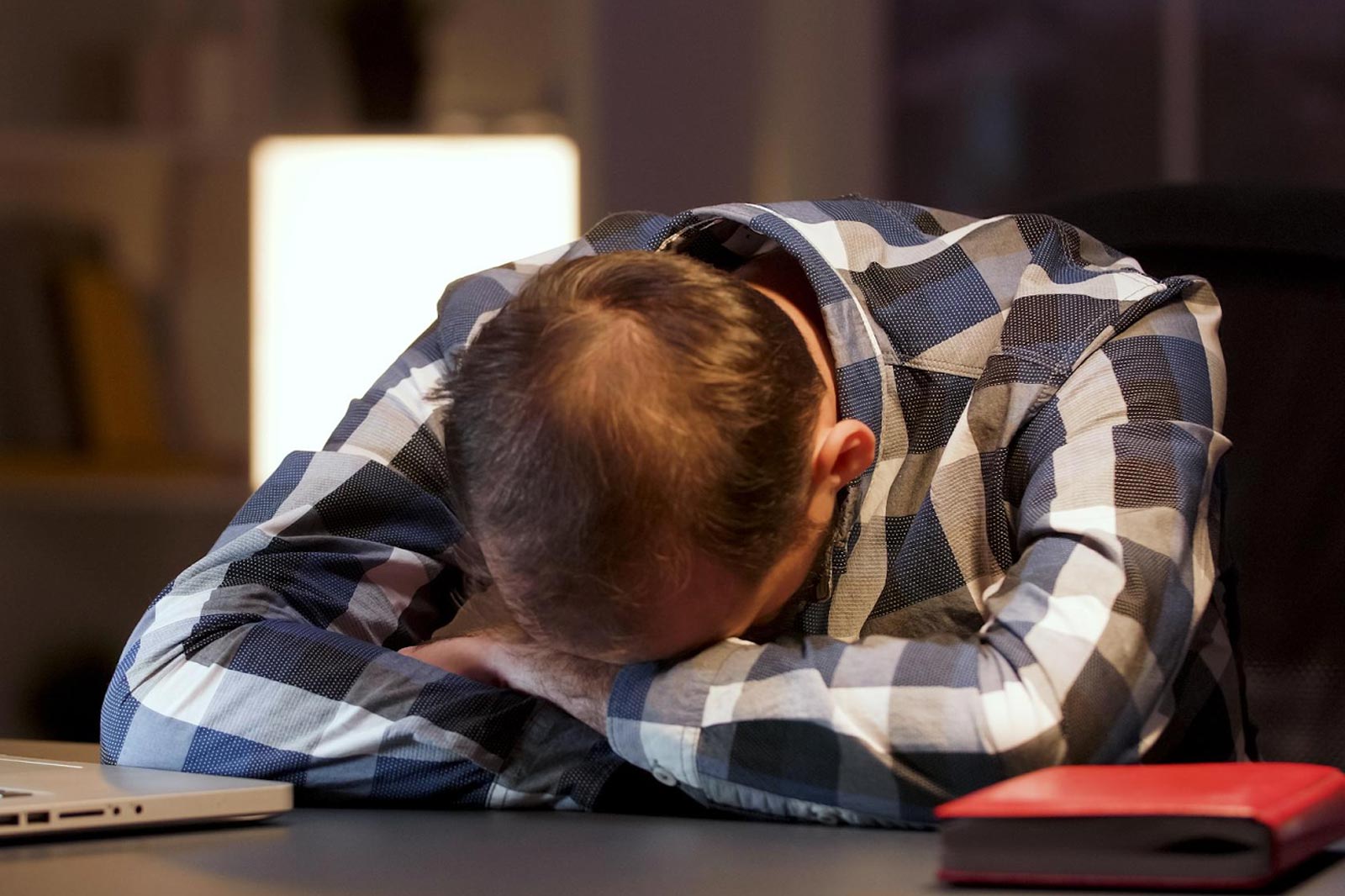 A tired man with his head down on a desk